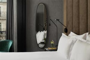 a bedroom with a bed and a mirror at NH Paris Opéra Faubourg in Paris