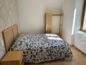 a bedroom with a bed with a black and white comforter at Appartement 4 personnes in Orbey