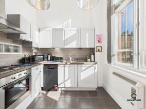 cocina con armarios blancos y lavavajillas negro en Duplex Apartment - Arts District Liverpool, en Liverpool 14 fotos más