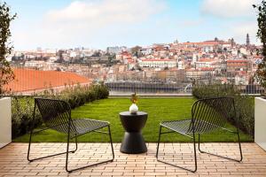 two chairs and a table with a view of a city at Tivoli Kopke Porto Gaia Hotel in Vila Nova de Gaia