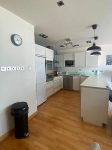 a kitchen with white cabinets and a clock on the wall at Rock view Apartment at ocean village in Gibraltar