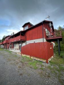 a red building with a red fence in front of it at Halek Hem - Haga studio in Enånger +8 photos