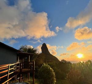 a view of a mountain with the sun setting at Casa do Ney in Fernando de Noronha