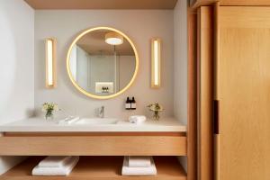 a bathroom with a sink and a mirror at Tivoli Estela Golf & Lodges Porto in Póvoa de Varzim