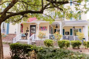 a yellow house with an american flag at Montgomery Inn BnB in Versailles
