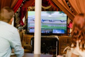 a man sitting at a table in front of a television at Montgomery Inn BnB in Versailles