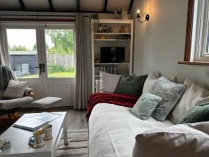 a living room with a couch and a table at Saving Grace with private hot tub in Bawdeswell