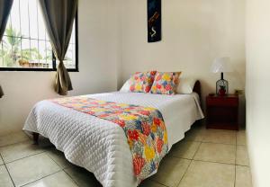 a bedroom with a bed with a quilt on it at Casa de Pablo in Puerto Ayora