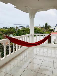 a hammock on a balcony with a view of the ocean at Casa de Pablo in Puerto Ayora