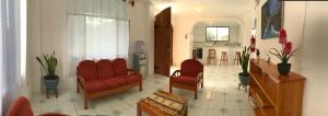 a living room with red chairs and a kitchen at Casa de Pablo in Puerto Ayora