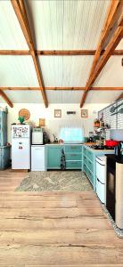 a kitchen with blue cabinets and a white refrigerator at La Cabane Caparica in Charneca