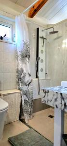a bathroom with a shower curtain next to a toilet at La Cabane Caparica in Charneca