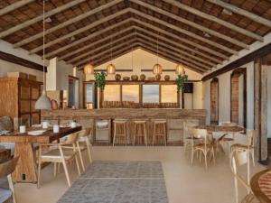 een keuken met houten plafonds en tafels en stoelen bij Casa do Amor Caraíva in Caraíva