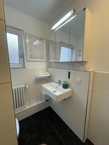 a white bathroom with a sink and a mirror at Studio-Parkplatz-Netflix-Balkon in Plochingen