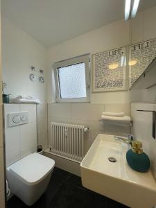 a white bathroom with a toilet and a sink at Studio-Parkplatz-Netflix-Balkon in Plochingen