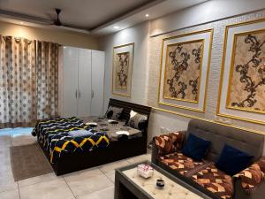 um quarto com uma cama e um sofá em Bell Rooms em Noida