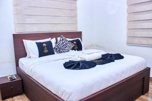 a bed with black and white pillows on it at Heiligtum Des Herrn Hotel in Winneba