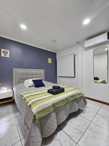 a bedroom with a large bed with a blue wall at Departamento moderno en el centro de Posadas in Posadas