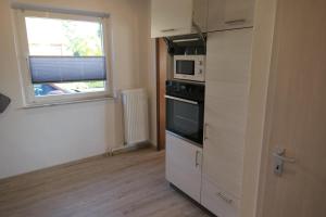 a kitchen with a stove and a microwave at FeWo Wrist in Wrist