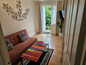 レディングにあるCozy Central One Bedroom Flatの茶色のソファとカラフルなラグのあるリビングルーム