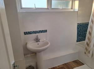 a white bathroom with a sink and a window at Cosy 2BR Retreat in Huntingdon near City Centre in Hartford