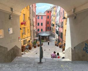 a group of people sitting on a street in an alley at Grande Cittadella Rooms in Genova