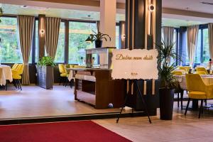 a restaurant with yellow chairs and a sign that says golden manil at Hotel Luna Bihać in Bihać