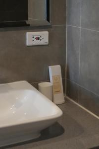 une salle de bain avec des toilettes blanches et un lavabo dans l'établissement Bruné - Parañaque, à Manille