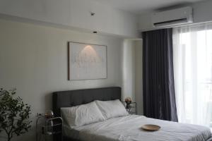 une chambre avec un lit et une grande fenêtre dans l'établissement Bruné - Parañaque, à Manille