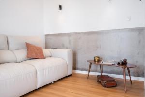 a living room with a white couch and a table at The Vinehill House in Câmara de Lobos
