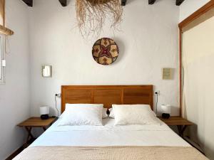 a bedroom with a bed and a clock on the wall at Casa Los Tres Stefan in Vejer de la Frontera