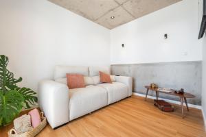 a white couch in a living room with a table at The Vinehill House in Câmara de Lobos