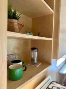 a cupboard with a green coffee mug and a pot at Riverside Retreat in Cowichan Bay
