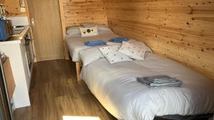 a pair of beds in a room with wooden walls at Taigh Plo in Lionel