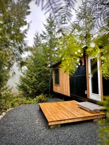 a small cabin with a wooden table in front of it at Riverside Retreat in Cowichan Bay