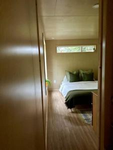 a bed in a small room with a window at Riverside Retreat in Cowichan Bay