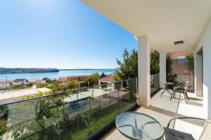 a balcony with a view of the water at Seaview Villa Summer with private pool & garden in Rtina