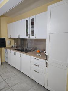 Una cocina con gabinetes blancos y un fregadero. en Villa Rosanna, en Caianello 28 fotos más