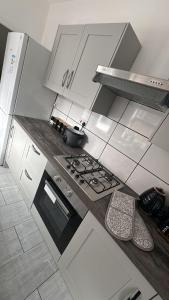 a kitchen with white cabinets and a stove top oven at City Escape Stylish 4 bedroom house in Nottingham in Nottingham