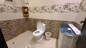 a bathroom with a toilet and a trash can at شقق العارض (2) in Riyadh