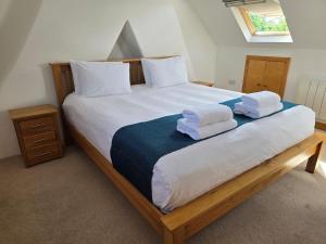 a bedroom with a large bed with towels on it at Villa at 58 London Rd in Amesbury +30 photos