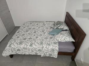 a bed with a blanket and pillows on it at Le Cataleya in Sainte-Rose