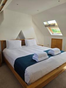 a bedroom with a large bed with towels on it at Villa at 58 London Rd in Amesbury
