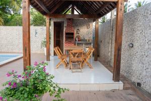 eine Holzterrasse mit einem Tisch und Stühlen darauf in der Unterkunft Casa, piscina, churrasqueira, 200m da praia- By OASIS FERIAS in Conde
