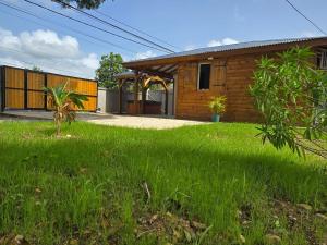 a house with a grass yard in front of it at Le Cataleya in Sainte-Rose +12 photos