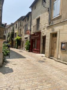 a cobblestone street in a town with buildings at La petite hostellerie in Uzès