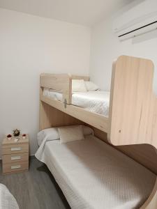 a bedroom with two bunk beds and a night stand at Apartamento Centro in Montoro +5 photos