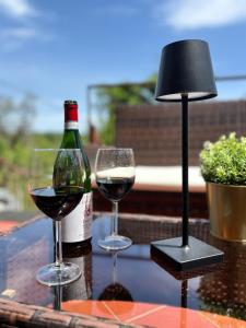 zwei Gläser Wein und eine Flasche auf dem Tisch. in der Unterkunft Ciury's Etna Holidays in Trecastagni