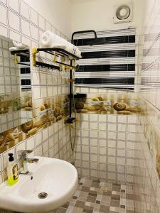 a bathroom with a sink and a tiled wall at Heiligtum Des Herrn Hotel in Winneba +13 photos