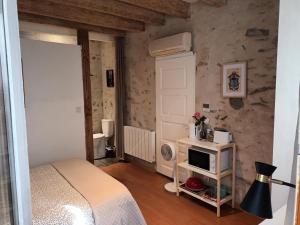 a bedroom with a bed and a microwave on a table at Charmante chambre bords du louet . in Rochefort-sur-Loire
